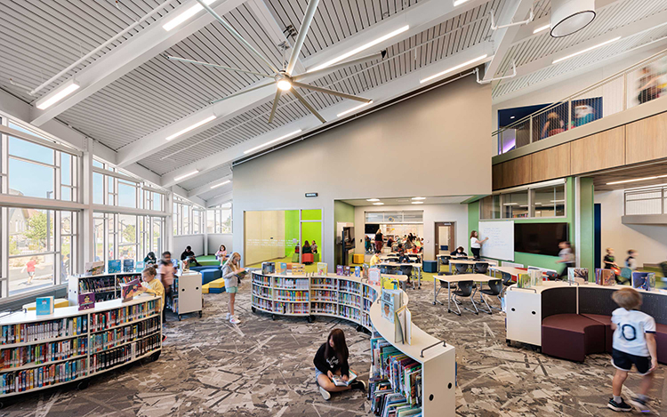 a colorful elementary school library with large windows several children are in the library looking at books