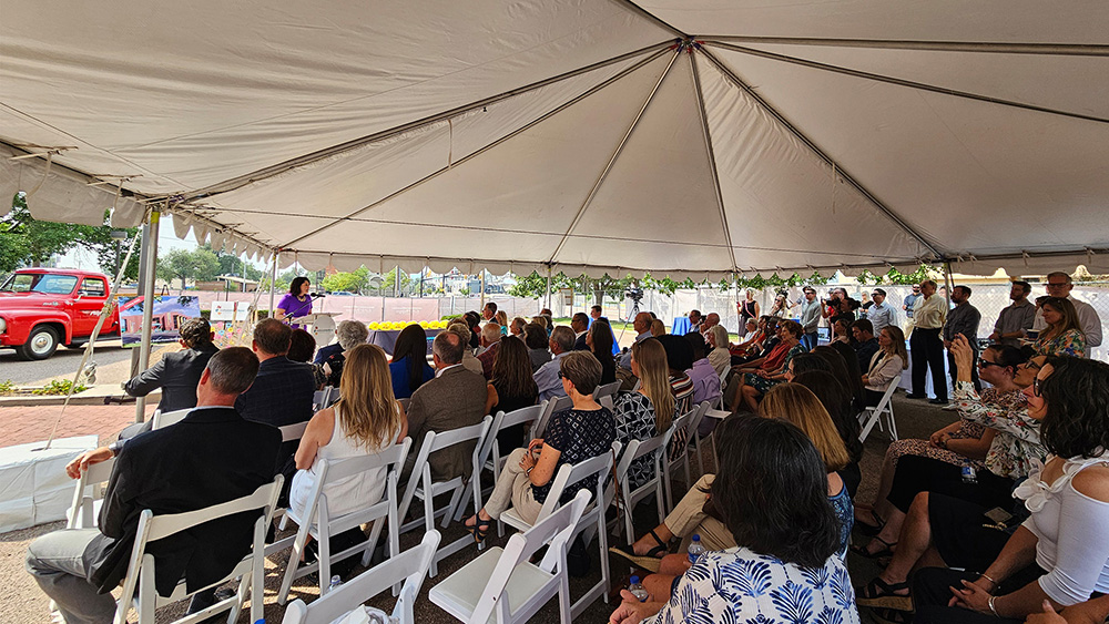 a crowd listening to another speaker at the groundbreaking ceremony