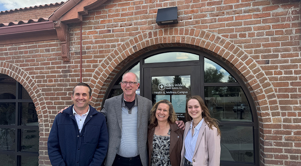 four people standing in front of the main entrance to the valley-wide health and wellness center